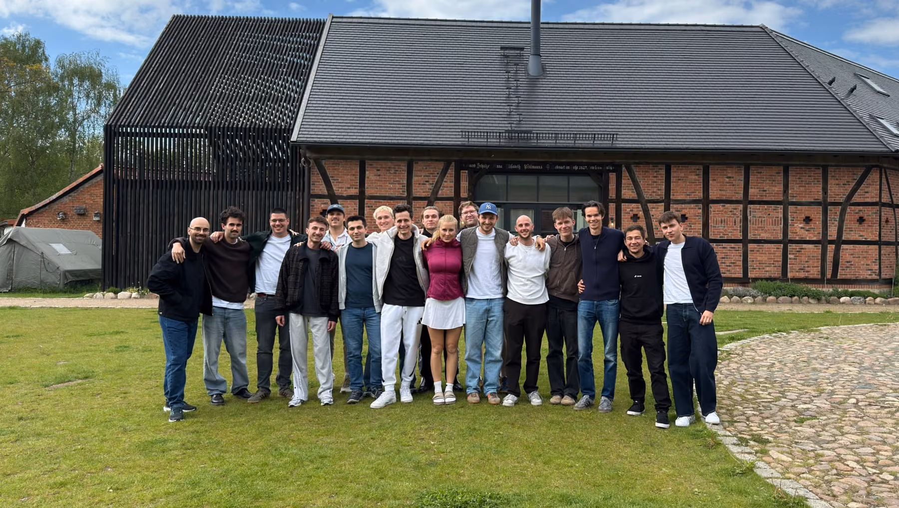 The Jamie team standing together in front of a brick barn